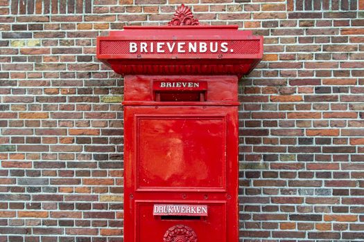 Brievenbus Hoorn in de binnenstad met rode PostNL-bus langs een straat richting het centrum