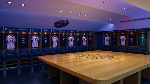 Smartphone met sportnieuws over Paris Saint-Germain, data-analyses en stadionverlichting als symbool voor modern voetbal