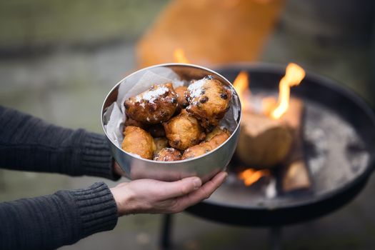 Opgewarmde oliebollen in een airfryer met poedersuiker op een bord in Hoornse wintersfeer