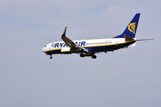 Vertrekhal met reizigers uit Hoorn die vluchtinformatie van Ryanair bekijken op een luchthaven